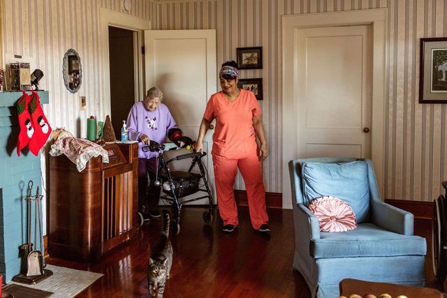 Home health care aide Tangie Enoch helps Savanna Hollar get around in her home near Yadkinville, N.C.