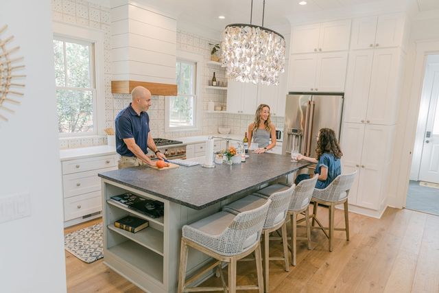 Ryan Malynn, Stephanie Trunzo and their 13-year-old daughter, Adelaide Trunzo Malynn, preparing dinner in the kitchen of the new home they retreated to on Daufuskie Island, S.C. The chandelier is made of locally sourced oyster shells.