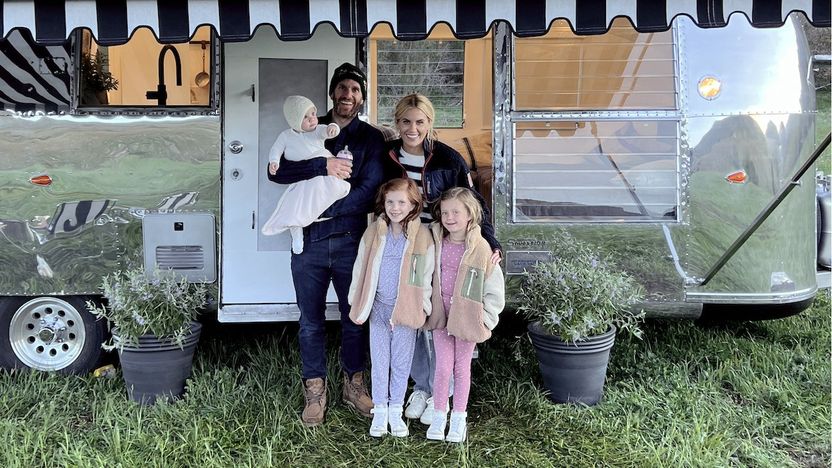 Shea and Syd McGee pose with their children in front of the family's renovated Airstream trailer.