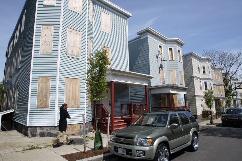  A man takes a lonely walk by a row of foreclosed houses on Hendry St. 